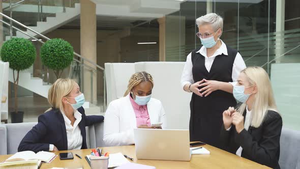 Team of Diverse Business Women in Medical Masks Coworking in Office During Pandemic Coronavirus