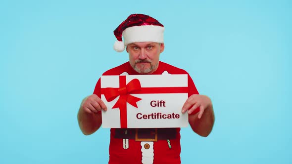 Funny Man Wears Red New Year Tshirt and Hat Presenting Card Gift Certificate Coupon Winner Voucher alt