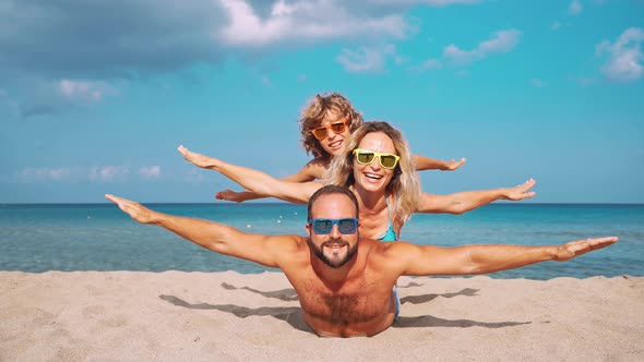 Father, Mother and Child against Blue Sea and Sky Background alt