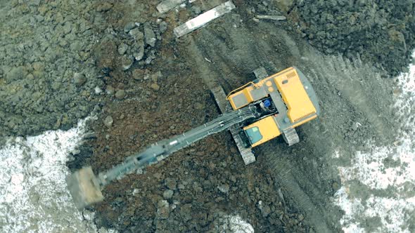 Metal Excavator Digs Sand with a Bucket at a Career. New Constructions Site alt