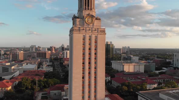 Slow drone shot of the UT tower with the hill country and downtown in the background. alt