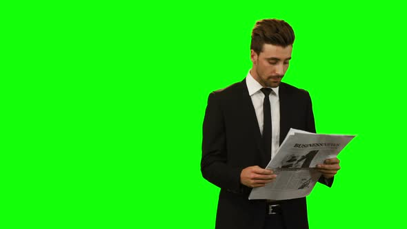 Businessman reading newspaper alt