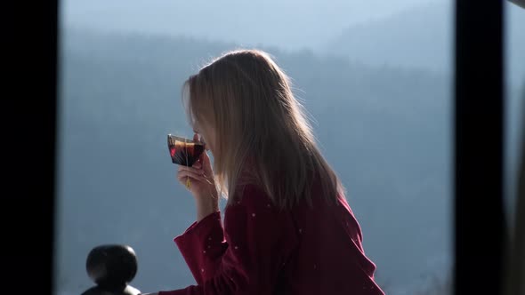 Young woman on balcony at chalet. alt