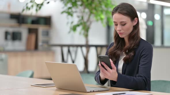 Businesswoman Using Smartphone and Laptop at Work alt