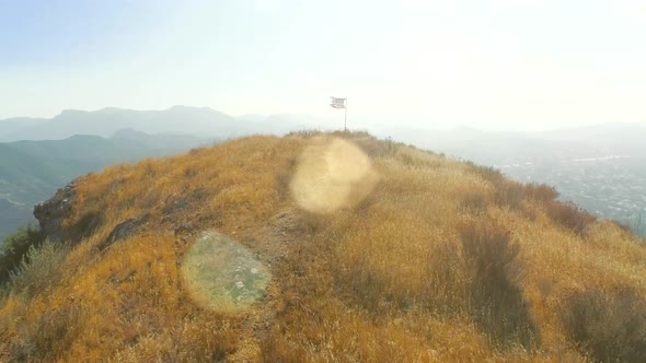 Approaching the Flag of the USA Waving at the Top of the Dry Hill alt