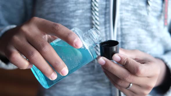Slow Motion of Hand Hold a Mouthwash Liquid Container alt
