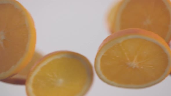 Fresh orange slices in circle shape collide each other in slow motion