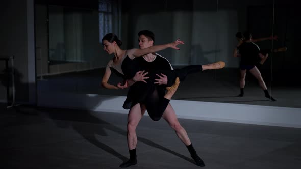 Cheerful Young Couple of Ballet Dancers Rehearsing Smiling in Studio Indoors alt