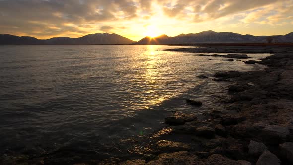 Colorful sunrise viewed from the edge of a lake alt