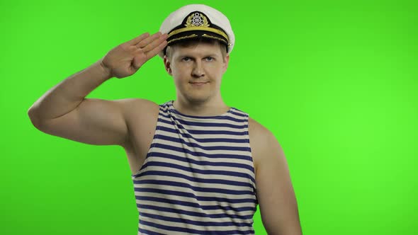 Young Sailor Man Salutes with Hand To Camera. Seaman Guy in Sailor's Vest alt