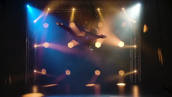 Flexible Aerialn Gymnast Rotates on a Circle and Performs Acrobatic Stunts in the Air. Young Girl in alt