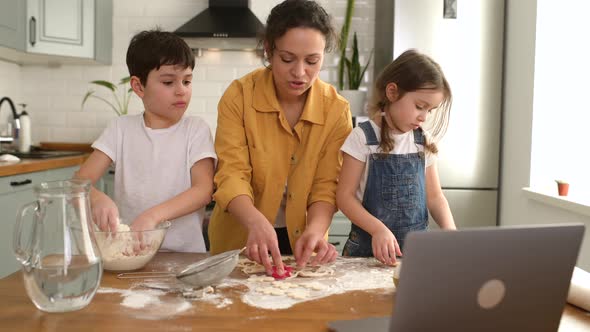 Mom and Kids Spends Leisure at Home Baking Cookies Looking Tutorial at the Laptop