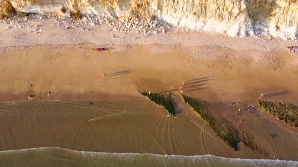 Aerial drone view of people on the beach during a beautiful sunset. Amazing vibrant colors.
