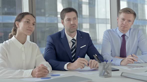 Middle Aged Business People Giving Introduction on Office Table alt
