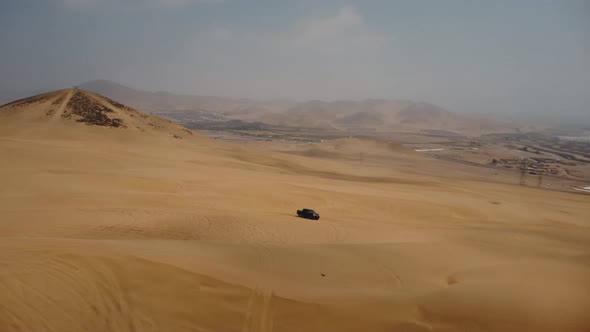 AERIAL - Off-road 4x4 truck tracks in Ica desert sand dunes, Peru, spinning shot alt