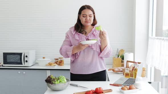 Worry Overweight woman eating salads for dieting weight loss.