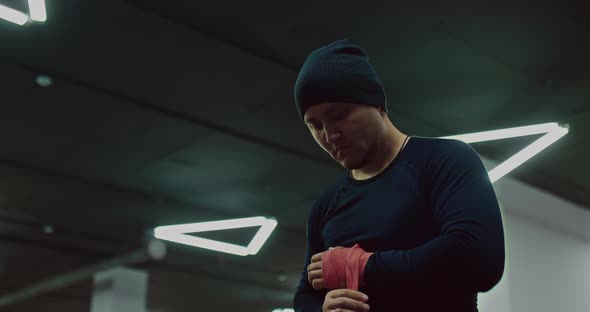 Serious Male MMA Fighter is Wrapping Hand for Protection Wrists Before Fight Portrait  Prores alt