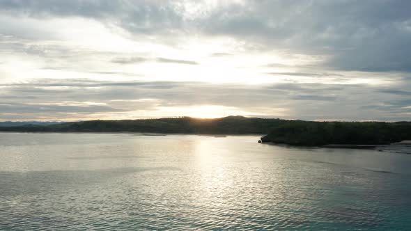 Paradise coast of Fiji during tropical sunrise with calm ocean surface, aerial alt