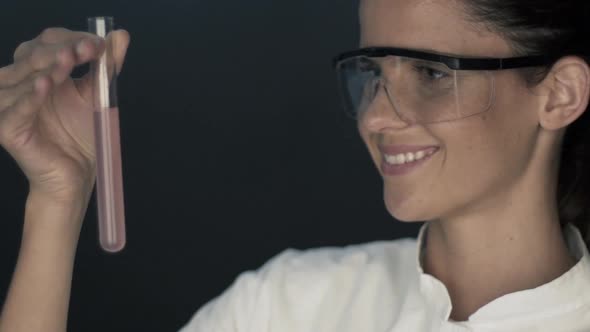 Scientist looking at test tube alt