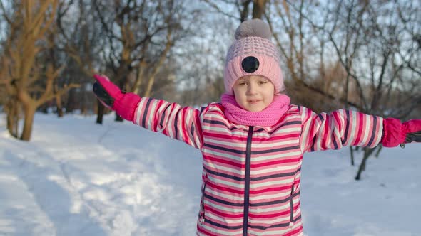 Joyful Child Kid Running Having Fun Dancing Fooling Around on Snowy Road in Winter Park Forest alt