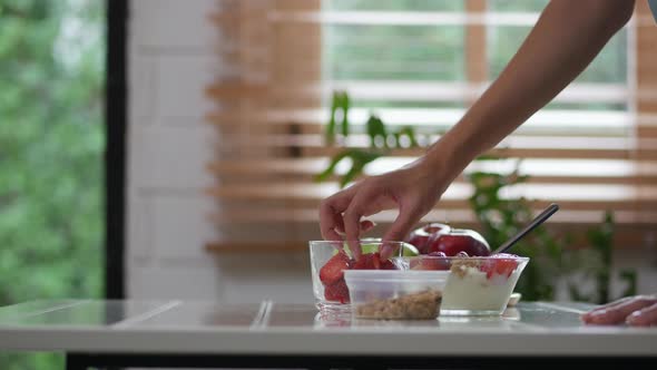 Close Up Asian woman ingredients for making strawberry smoothies cooking a healthy breakfast. alt