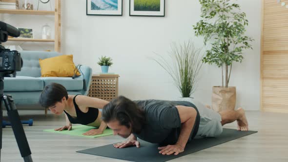 Young Couple Working Out and Speaking Recording Video for Sports Blog Using Camera alt