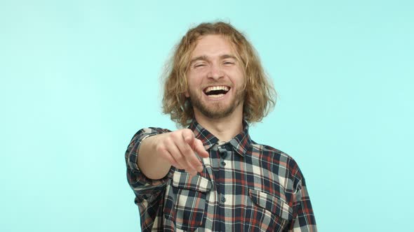 Slow Motion of Handsome Blond Guy Laughing at Something Funny Pointing Finger at Camera and Chuckle