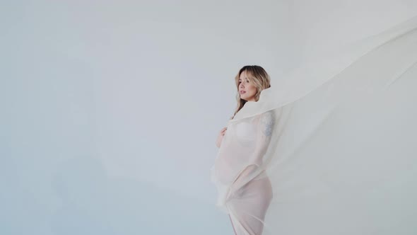 Nude Pregnant Pretty Woman in Underwear and Fluttering Fabric Slik alt