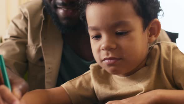 Dad supporting his kid to draw