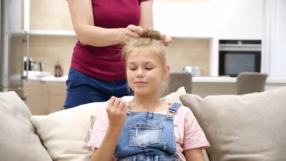 Cropped Hands Of Mother Making Her Daughter Ponytail Hairstyle and Bun Slow Motion