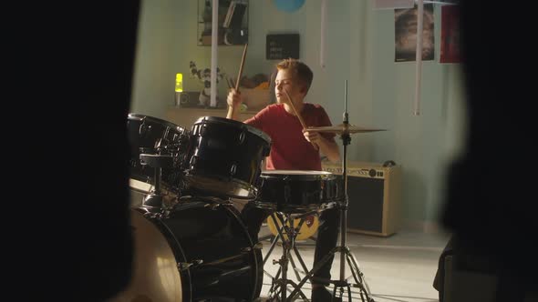 Teenager Learning to Play Drums at Home alt