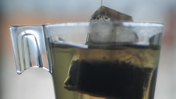 Tea bag in glass cup slow motion