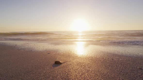 Sunset and sea with waves and blue sky on empty sunny beach alt