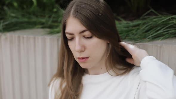 Young Female in Garden Using Laptop Communicates on Internet with Customer