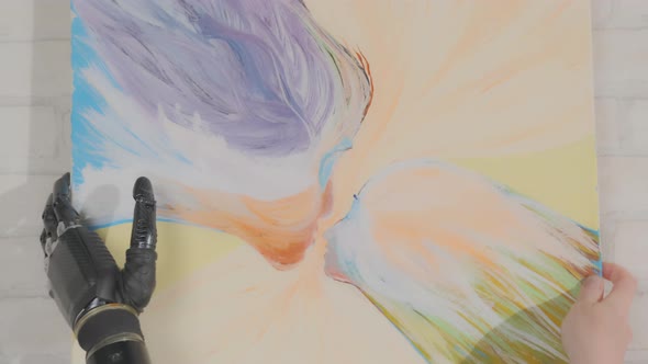 Disabled person with prosthetic hand hangs abstract picture on wall, alt