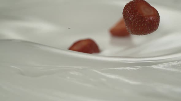 Fresh strawberries rain on yogurt in slow motion – Close up