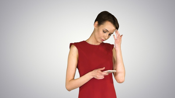 Young happy attractive female in red dress texting on the alt