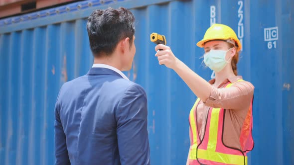 Technician or engineer worker woman use infrared thermometer measure temperature of staff alt