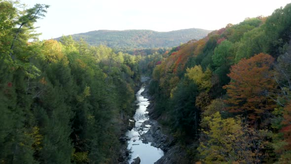 Aerial Drone Flight Through Fall Foliage Inside Quechee Gorge in Vermont, USA Featuring Colorful Aut alt