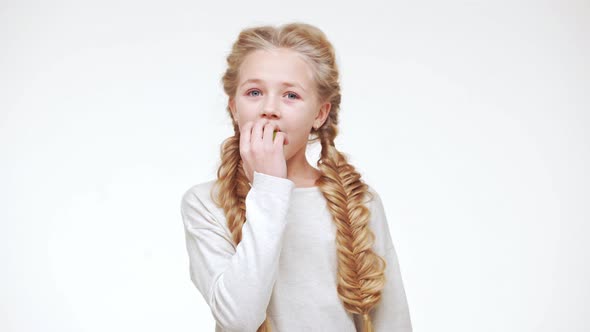Young Adorable Caucasian Girl with Long Pretty Blonde Hair Eating Apple with Pleasure on White alt