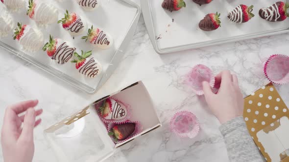 Flat lay. Step by step, Packaging chocolate dipped strawberries into a paper box for a gift alt