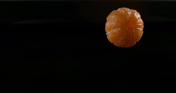Clementines, citrus reticulata, Fruits falling on Water against black Background, Slow Motion 4K alt