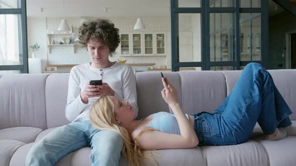 Couple of Teens Sitting Back to Back with Their Phones Social Media Addiction alt