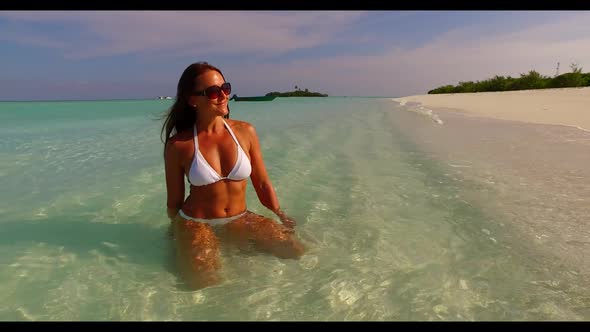 One woman sunbathing on relaxing bay beach vacation by transparent water with white sand background  alt