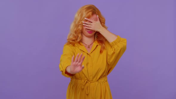 Lovely Girl in Yellow Dress Closing Eyes Showing Stop Gesture Confused Shy Scared to Watch alt
