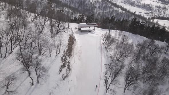 Flying over rope-way with gondolas at mountain resort Crystal Park in Bakuriani. Snowy winter day. alt