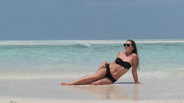 Young Woman in Bikini Tans on an Empty Paradise Beach on Island in Ocean Mnemba alt