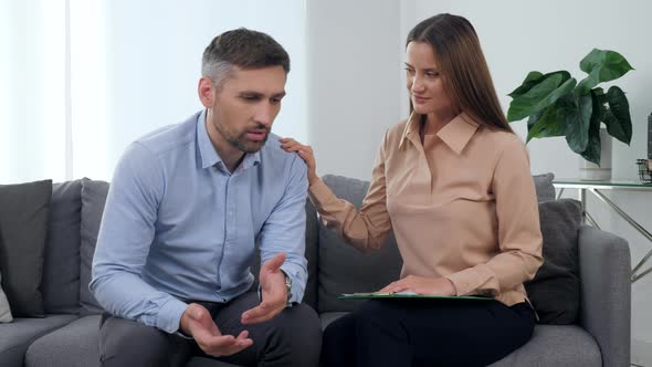 Sad Man Patient Talking About His Problem with Woman Psychologist Supporting Him alt