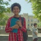Pretty Smiling African American Female Student with Textbooks Posing Outdoors - VideoHive Item for Sale