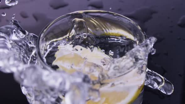 lemon drop into cup full of water 